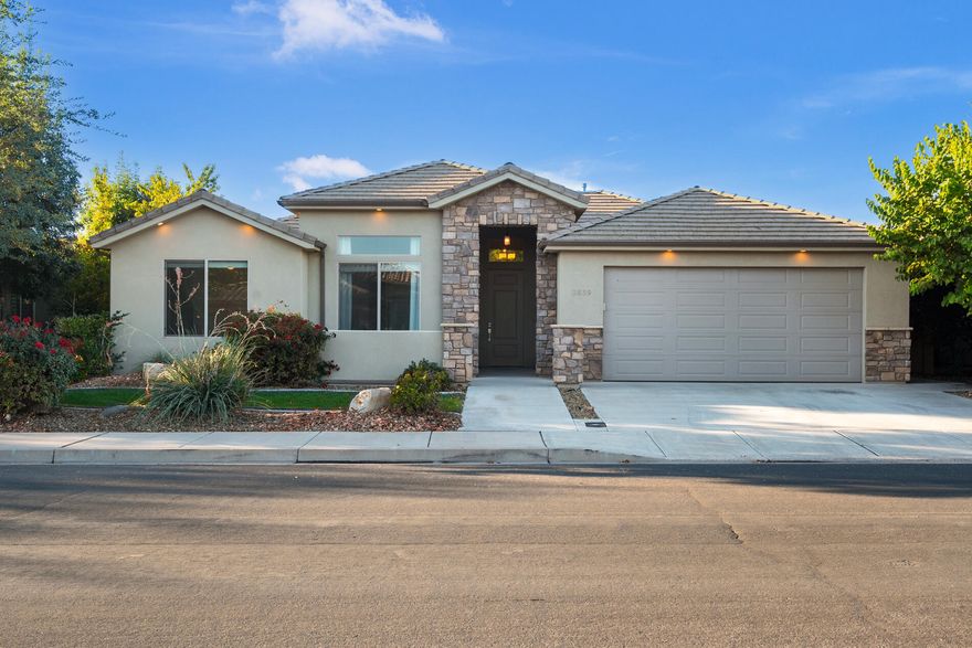 Charming single-level home in Santa Clara. This ideal location is walkable to restaurants, stores, & a park. Inside, this beautiful home features a gas fireplace, built-in entertainment center, plantation shutters, vaulted ceilings, 8-foot tall doors, cased windows, ceiling fans in all the bedrooms & great room, carpet, & new LVP flooring. In the kitchen, enjoy a gas range, stainless steel appliances, white cabinets, granite countertops, & a tile backsplash. The primary suite includes a large walk-in closet, & a separate tub, shower, water closet, & two vanities. Fridge, water softener, a one-year-old washer & dryer are included. Outside, you'll find a front courtyard, two covered back patios, & a fully fenced yard. Close to hiking, biking, Tuacahn Amphitheatre, & Snow Canyon State Park.