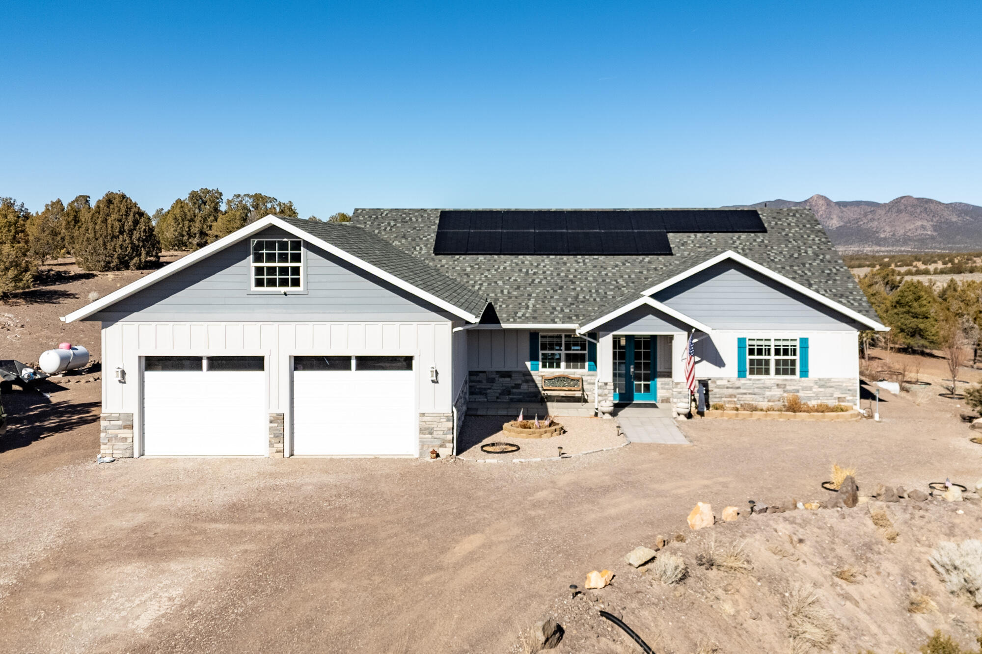 Experience the perfect blend of modern design and open living in this stunning 2020 home that backs up to the national forest with BLM mitigation on the north side of the street.  With spacious interiors flooded with natural light and surrounded by serene landscapes, it offers a peaceful retreat without sacrificing style. Discover your dream home featuring a cozy loft area, complete with eco-friendly solar power, a covered RV pad with convenient hookups, a fully owned propane tank, tankless water heater, full power back up generator, Aquasana filter  and a monthly water fee of just $45.