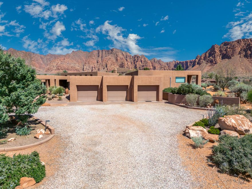 Tucked into an exceptional 2.65-acre lot in the heart of Kayenta, this expansive 4,220 sq ft home—including a 3,372 sq ft primary residence and 848 sq ft indoor pool house—seamlessly blends architecture with the red rock desert. Originally a Parade of Homes winner for Best in Show, Craftsmanship, Floor Plan, and Curb Appeal, this home captures the essence of desert living. The open-concept design features a spacious Great Room with soaring ceilings, a cozy fireplace, and floor-to-ceiling windows that showcase panoramic views from nearly every room. A private guest wing offers two spacious bedrooms and a full bath, each with direct access to the back courtyard and pool. The owner's wing includes a peaceful primary suite with a fireplace, private pool access, and stunning views. Designed for both comfort and flexibility, the home includes two additional spaces that can be utilized for an office, library, or formal dining. Ten skylights fill the home with natural light, while thoughtful features like Hunter Douglas blackout blinds, ceiling fans, and central vacuum enhance daily living. The 3-car garage offers 1,067 sq ft of space, and the home is powered by 39 owned solar panels & 6 batteries. Built in 1993 and exceptionally maintained, this property offers refined quality, energy efficiency, and timeless design. Located in one of Ivins most sought-after communities-- Kayenta.  This home isn't just a residence, it's a serene desert retreat where peace, privacy, and endless views create an extraordinary lifestyle. Sellers are motivated.