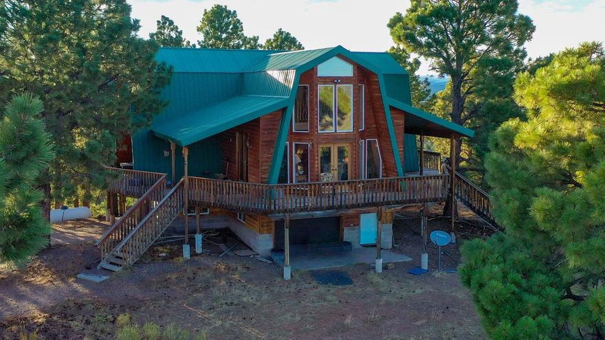 Lovely mountain cabin with beautiful views! Multiple decks. 3 bedroom 3 bath with garage in basement and an additional partially finished 3000 sq ft detached garage/workshop with living quarters. Cabin has a 10,000 gallon water tank and water shares in a community well.