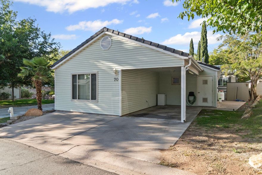 Feel like you're going on vacation as you come home each day to this peaceful community surrounded by Coral Red Mountains in the hidden Harrisburg Estates. RARE price tag for a single family stick built property in Southern UT! Interior features include LVP flooring, open concept kitchen / living w/ island-breakfast bar, 2nd flex room, full guest bath w/ laundry closet, primary bedroom with 2 way fireplace to your ensuite bath (complete with jetted tub & separate walk-in shower!)  Outside you can enjoy a private patio w/ awning for shade and perfect for cook-outs, a storage shed for all that extra stuff, covered carport w/ spacious attic, front deck/parking, and a grassy dog park just steps away. Or take a quick stroll to your community clubhouse for a dip in the pool and hot tub soak!