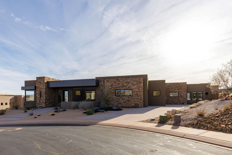 Stunning single-level home located in the prestigious, gated Ledges community, surrounded by some of the most breathtaking natural scenery Southern Utah has to offer. The spacious backyard is anchored by a saltwater pool with motorized cover, built-in hot tub, and shallow sun shelf, creating an ideal setting for both relaxing and entertaining. Multiple western slider doors provide a true indoor-outdoor living experience, seamlessly connecting the living spaces to the outdoors. The gourmet kitchen features custom flush-mount cabinetry, Monogram appliances, quartz countertops, under-cabinet lighting, and a butler's pantry, making it both beautiful and highly functional. The private primary suite offers a luxurious bathroom & closet with a curbless walk-in shower with linear drain, sleek standalone tub, custom cabinetry, and laundry hookups. The thoughtfully designed floorplan includes four bedrooms, each with its own elegant en suite bathroom and walk-in closet, pool bathroom, tall ceilings throughout, and expansive windows that flood the home with natural light. Residents of The Ledges enjoy the epitome of golf course living, with a premier clubhouse and restaurant, driving range, and 18 championship holes just minutes from the home.