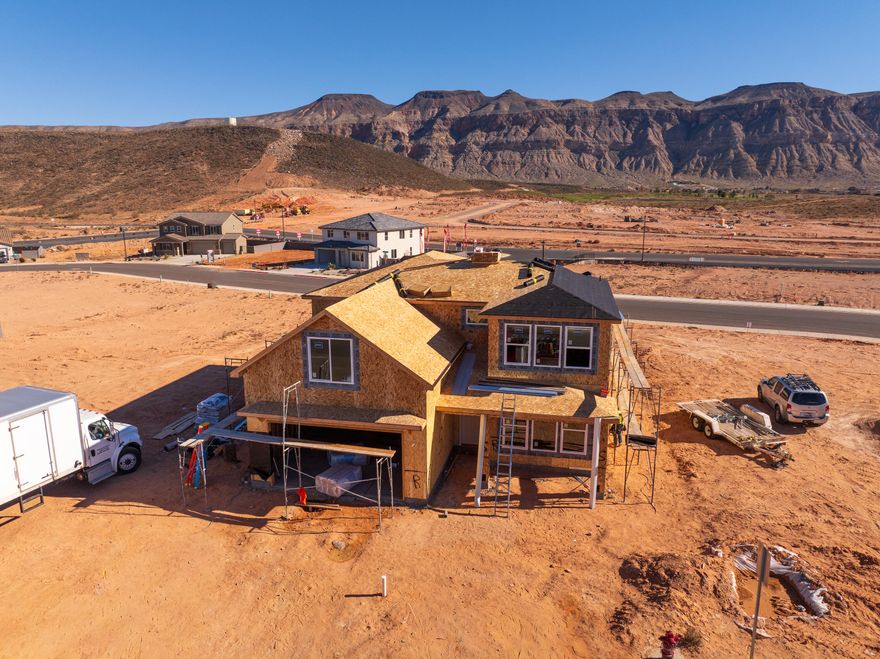 Now under construction with a unique lot and great views. 5 bedrooms (primary on main) + office/den, RV/boat parking, and no rear neighbors. The lot spans from street to street, offering privacy and the ability to add a detached garage/ADU at the back or create a pull-through driveway. Quiet community great for family, just minutes to BLM land, Sand Hollow Reservoir, and golf. Excellent floor plan with 2x6 exterior walls. Block walls installed on both sides and across the back with gate access. Large backyard with covered patio and evening shade. 2-car garage deep enough for truck/SUV. Includes 1-year builder warranty. Estimated completion February 2026.