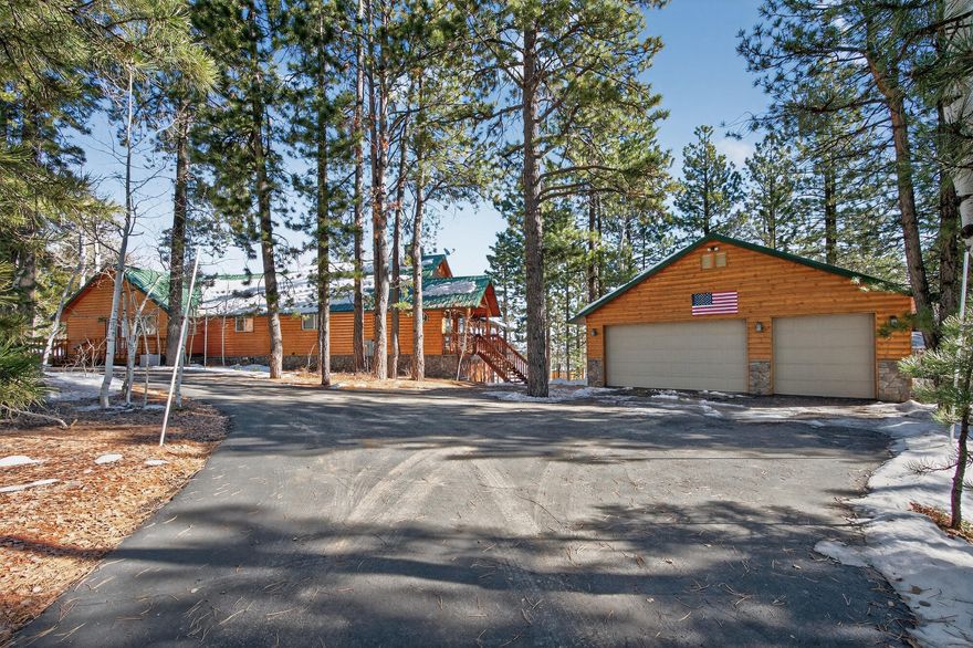 This 4,843 sq ft cabin, nestled on just over an acre next to BLM land and the Dixie National Forest, offers stunning views and privacy. With two bedrooms, a den, and an office that can be used as extra bedrooms, this cozy retreat includes 2.5 bathrooms, walk-in closets and a lot of storage! Modern comforts like two furnaces, A/C units, and two wood stoves ensure comfort, with remote-controlled heating for convenience. The main floor features a large kitchen and two spacious family rooms with high ceilings and big windows for breathtaking views and natural light. The primary bedroom has a private bathroom and a large walk-in closet, with easy outdoor access from the bedroom and adjacent den/office. Downstairs, find a versatile space for a living room, gaming area, gym, or bedroom, plus a second bedroom. Ample storage includes a 720 sq ft detached garage, a 144 sq ft shed, and more under the deck. A paved driveway and lush backyard with a sprinkler system make this cabin a perfect escape. It's a unique retreat that was meticulously taken care of. *Furniture is negotiable. Boards are on windows to protect from ice.