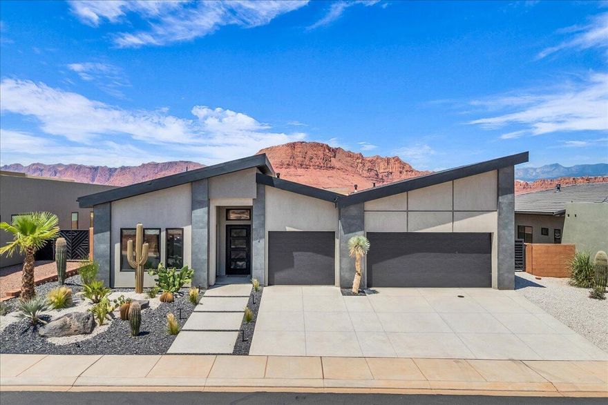 This modern luxury home boasts breathtaking Red Mountain views, perfectly capturing the natural beauty of the surrounding landscape. Located in close proximity to popular destinations like Black Desert Resort, Snow Canyon State Park and Tuachan Amphitheater. The chef's kitchen is a culinary haven featuring high end appliances, rich walnut cabinets and stunning quartz countertops. Additional features include motorized blinds, epoxy floors, remote controlled patio misters, wrought iron front door and impressive office area with glass doors. Large windows throughout the home frame the majestic views. Guest bedroom with private outside entrance offers flexibility and comfort for guests. Expansive outdoor space for seamless indoor/outdoor living with covered patio and built in gas firepit. This exceptional property offers the ultimate luxury living experience.