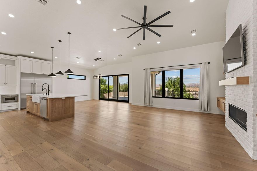 Perched at the top of Tonaquint with sweeping views of Snow Canyon, Pine Valley and Zion, this custom home blends luxury, functionality, and comfort. It features a main-level 4-car garage, a lower 2-car garage or shop, and a spacious cold storage bunker. Inside, you'll find two full kitchens—upstairs and downstairs—with the lower-level kitchen offering a sliding window that opens to the pool area for a seamless indoor/outdoor living experience. The master suite includes a steam shower, built-in sauna, and private view deck. Each bedroom features its own ensuite bathroom and walk-in closet. Additional highlights include a 13-foot-deep pool, large hot tub, fully equipped indoor gym, and a private theater room designed for the ultimate in-home entertainment. This home delivers on every level