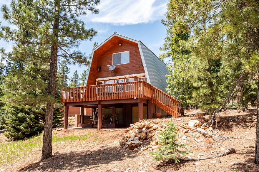 Welcome to this perfect mountain retreat! Get comfortable in the middle of Utah's stunning natural beauty. This mountain cabin, warm and charming, features three cozy bedrooms and two bathrooms across 1,325 square feet. Upstairs, two spacious bedrooms with custom furniture share a full bathroom. The main floor houses another bedroom with a queen bed and a full bathroom. The kitchen, thoughtfully designed, boasts unique cabinetry, a custom backsplash, and a farm sink. Modern amenities include a dishwasher, a new furnace, and updated plumbing. Adjacent is a laundry room with a stacked washer/dryer and built-in ironing board. The living room, flowing from the kitchen, exudes rustic charm with pine walls, custom blinds, and wood laminate flooring with a pellet stove. The front deck, with a retractable canopy, is perfect for gatherings under the Utah sky. Additional features include a second laundry area in the garage, partial basement storage, and a detached two-car garage with workspace and storage. Cabin location sits in the middle of plenty of National Parks, trails and lots of fishing opportunities. HOA covers snow removal and water. Property can be used as a short-term rental.