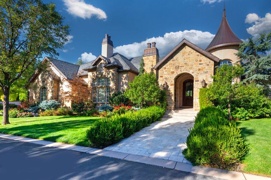 Step inside to the timeless elegance of this magnificent European-style estate, gracefully situated within one of Holladay's coveted gated communities. This distinctive architectural masterpiece is appointed with a generous five-car garage, a private elevator for effortless access, and a gracious entryway that truly promotes sophisticated living. Inside, two opulent master suites are linked by a hallway adorned with Crema Marfil marble, while the awe-inspiring two-story family room, featuring spectacular exposed beams and vast windows, flows seamlessly into a gourmet kitchen. The kitchen boasts Two Double Side by Side Fridges with Custom Cabinetry and Two Dishwashers. The lower level presents three additional bedroom suites, a relaxing sauna, a shower, and a dedicated, state-of-the-art theater room for optimal entertainment. Wander outside to a serene, covered deck overlooking a vibrant garden area complete with stately mature trees, exquisite colorful shrubs, and soothing tranquil waterfall. Enjoy peace of mind with a Backup Generator. With its updated, move-in ready condition and prime location just minutes from the 215 freeway, downtown, and ski resorts, this enchanting residence is a true must-see! Square footage is provided as a courtesy only. Buyer is advised to obtain an independent measurement and to verify all information.