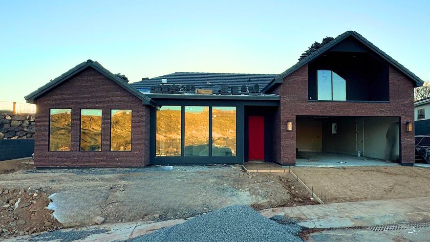 Nestled on the bluff overlooking the Virgin River, this new custom-built home in Falcon Ridge perfectly blends modern comfort with stunning natural surroundings. Every detail was designed to maximize the breathtaking views and create a relaxing lifestyle.
The open-concept layout is complimented with luxury vinyl plank flooring, knotty alder cabinetry, and quartz countertops, upgraded fixtures and designer details throughout. The wall to wall windows fill the  with main living area with natural light and allow you enjoy the breathtaking views no matter where you are. The primary ensuite offers a spa-like retreat with a spacious bath and walk-in closet.

Upstairs, you'll find a second living/rec room with a wet bar, bedroom, and bathroom — complete with a private entrance, , ideal for a guest suite or overnight rental opportunity. Take in the most incredible sunrises from the upper, covered balcony, where the panoramic views steal the show.

The massive 4-car double tandem garage provides plenty of room for all the outdoor toys.

Located just 30 minutes from Zion National Park and St. George, and only 15 minutes from Sand Hollow and Quail Creek Reservoirs, several world class golf courses, and unlimited hiking, biking, fishing and boating options. Fire up your UTV and make the quick drive to miles of dunes and trails. This property is the perfect blend of tranquility and adventure. It's not just a home - it's an experience.