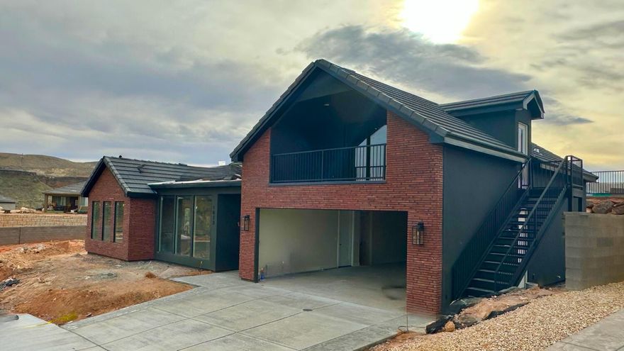 Nestled on the bluff overlooking the Virgin River, this new custom-built home in Falcon Ridge perfectly blends modern comfort with stunning natural surroundings. Every detail was designed to maximize the breathtaking views and create a relaxing lifestyle.
The open-concept layout is complimented with luxury vinyl plank flooring, knotty alder cabinetry, and quartz countertops, upgraded fixtures and designer details throughout. The wall to wall windows fill the  with main living area with natural light and allow you enjoy the breathtaking views no matter where you are. The primary ensuite offers a spa-like retreat with a spacious bath and walk-in closet.

Upstairs, you'll find a second living/rec room with a wet bar, bedroom, and bathroom — complete with a private entrance, , ideal for a guest suite or overnight rental opportunity. Take in the most incredible sunrises from the upper, covered balcony, where the panoramic views steal the show.

The massive 4-car double tandem garage provides plenty of room for all the outdoor toys.

Located just 30 minutes from Zion National Park and St. George, and only 15 minutes from Sand Hollow and Quail Creek Reservoirs, several world class golf courses, and unlimited hiking, biking, fishing and boating options. Fire up your UTV and make the quick drive to miles of dunes and trails. This property is the perfect blend of tranquility and adventure. It's not just a home - it's an experience.