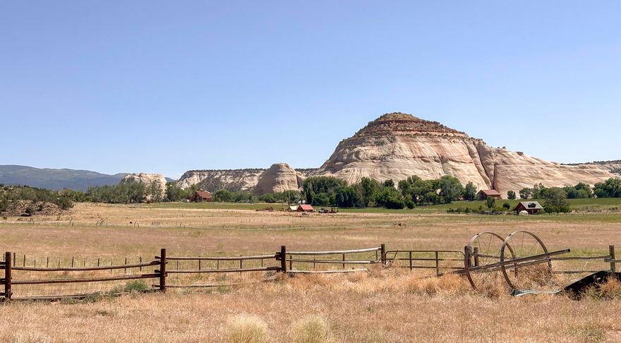 Deer Ranch is a gorgeous 80 acre parcel with picturesque views in every direction. Huge price reduction! Includes 2 small cabins-each with 1 bed/1 bath & full kitchen. Main home has beautiful log beams, trusses, open floor plan & hardwood floors w/ front porch for relaxing & watching the sunset after a great day on the ranch. Approx. 30 acres of irrigated alfalfa fields, with 30 ''A'' shares of irrigation. Two wells, one for the cabins & one for a for a future homesite in the NW corner of property. New septic and electric stubbed to this elevated setting, providing unbelievable views of the surrounding sandstone buttes of Sugarloaf & GSENM.  Perfect for your future dream home or friends to stay in their RV. Rare find in Boulder with new price - one of a kind Located between Bryce Canyon NP & Capitol Reef NP in a beautiful part of So. Utah. Bring the horses, toys or both. Huge barn with chicken coop, carport, and a large concrete pad with power for future garage or shop. SECOND HOME is a sweet ''Tiny Home'' with a cottage feel. Privacy, Large shade trees, green grass, beautiful views, irrigated land - THIS IS A DREAM COME TRUE! 4 wheel lines included. Potential for lot split or subdivision with City approval. Seller has preliminary concept plans completed - call for details. Fiber is in area, but not completed to property yet. Sq Ftg shown is for both properties, both are one level cabins. Occupied, please do not drive through private property - Agent must be present for showings. Call for appt. Don't miss this one of a kind property with tons of potential! 

See video of the property here- https://youtu.be/iaaOZFjwcG8?si=EcYzbmXXPtCLr2Sk