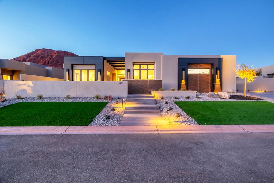 Welcome to your dream oasis nestled in the heart of Ivins! This new construction home is amongst the final gems to be built in The Palisades at Snow Canyon. Boasting a stunning desert contemporary design and top-tier finishes, this 3-bedroom plus den, 3.5-bathroom home offers jaw-dropping views of Red Mountain and The Vermillion Cliffs, especially from the rooftop patio! The master suite with a custom sauna welcomes you everyday.  Need an RV Garage?  This home has one with a 12 foot tall garage door and over 1250 square feet of garage space.  Imagine lounging by an incredible private pool, warmed by dancing fire features—sounds like a permanent vacation, right? As part of a gated community, enjoy access to a clubhouse, pool, spa, and an exercise room, not to mention 5 pickleball courts, a tennis court, and a basketball court. Plus, forget lawn care; it's all handled by the homeowners association. Whether you're pickleball pro or a relaxation enthusiast, this home checks all the boxes for a blissful lifestyle. Welcome home to luxury living at its finest!