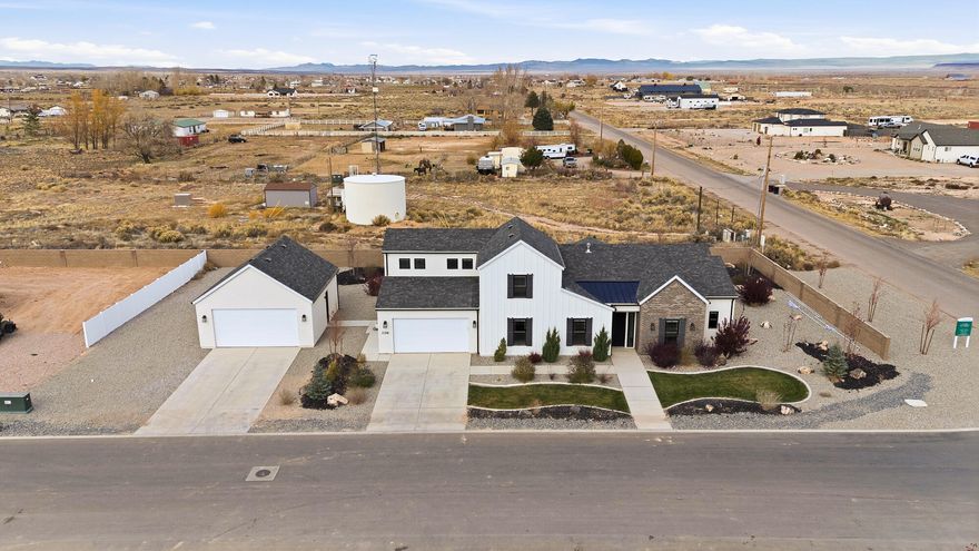 This beautiful brand-new home in the highly sought-after Painted Desert Subdivision offers modern farmhouse charm with thoughtful design throughout. Sitting on a .40-acre corner lot, the property is fully landscaped & move-in ready. With 5 bedrooms, 3.5 bathrooms, and 2,820 sq ft, this home offers a spacious, open floor plan perfect for everyday living & entertaining. The inviting living room features floor-to-almost-ceiling sliding doors, flooding the space with natural light & providing a beautiful view of the covered patio and backyard. A cozy fireplace with built-in shelves & cabinets adds warmth & function. The kitchen has modern finishes, a large walk-in pantry, & an easy flow into the dining and family areas. An office/den is conveniently located off the entryway, providing a quiet workspace or flex room. Upstairs, you'll find a second family room above the garage - complete with its own bathroom - making it ideal for guests, recreation, or a media room. The primary suite offers a relaxing retreat with a spacious walk-in closet, dual sinks, and a large walk-in shower. Parking and storage are abundant with a deep 3-car attached garage plus a 2-car detached garage, perfect for vehicles, toys, or a workshop. Located just minutes from Cedar City and convenient to shopping, dining, and outdoor recreation. New, never occupied - a rare opportunity in one of the area's premier new communities!