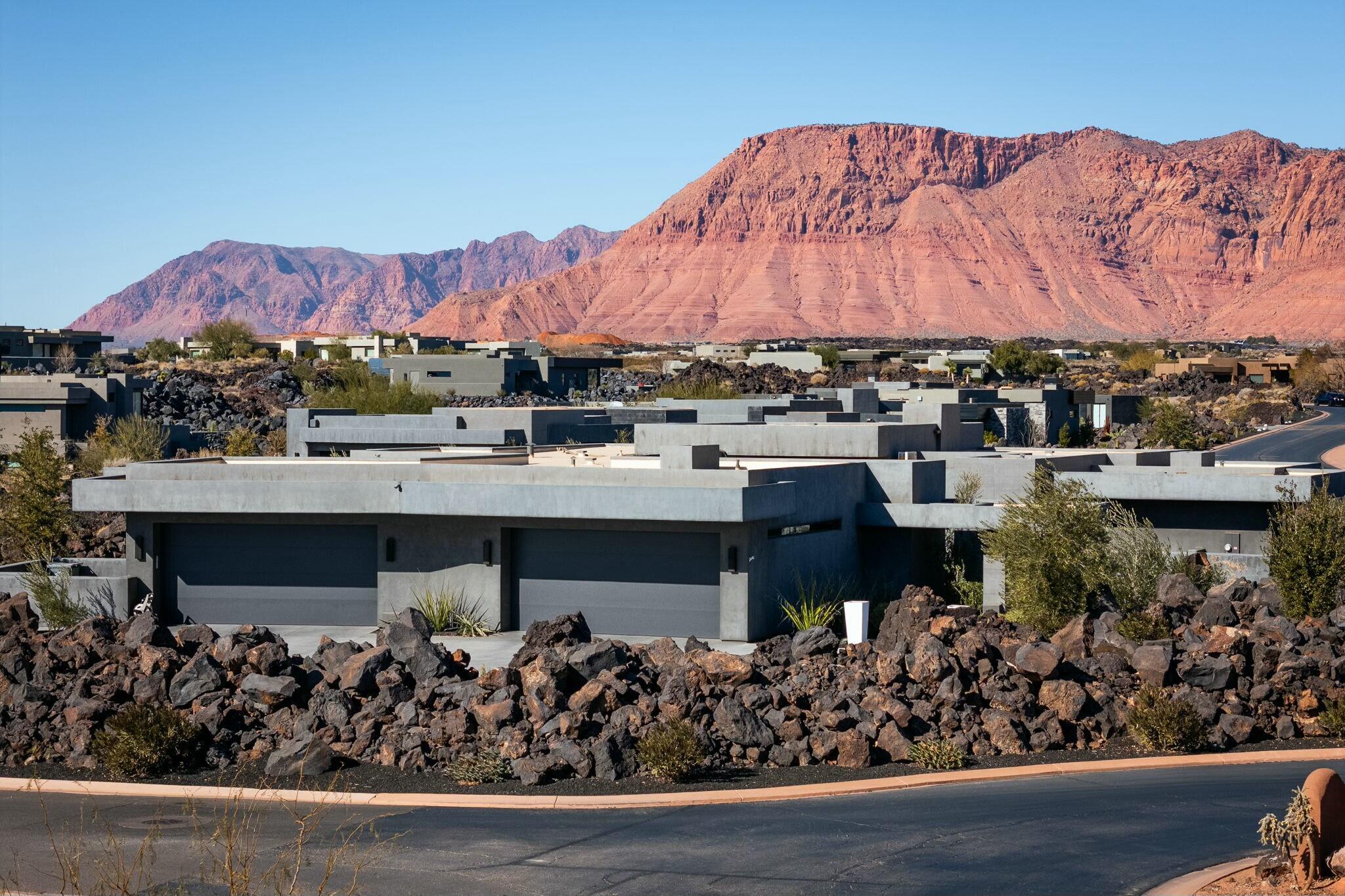 Sitting on a rare .99 acre prime peninsula homesite in the lava fields of the highly desired four-season Private Resort of ENTRADA @ Snow Canyon Country Club is this custom Split Rock built luxury residence with sweeping views of the beautiful vermilion cliffs and Snow Canyon corridor in Southern UT. This meticulously crafted home is designed for entertaining, featuring walls of glass that enhance a seamless indoor/outdoor feel. There is a meandering walk to the front door with a lava rock fire feature in the entry courtyard. With lush landscape including mature olive trees for privacy, this home was thoughtfully designed to be your own personal resort! Designed with 4 spacious bedroom suites-1 currently used as a Billiards rm and 1 as a spectacular high-end Theater with 7 reclining seats This custom furnished home features: Oak floors, high end WOLF appliances with secret kitchen pantry, 12' granite waterfall island, electric roller shades, tinted windows to reduce ultraviolet rays, several custom track lighting systems to accentuate artwork, electric light dimmer switches throughtout that can be voice controlled to provide unlimited lighting scenes at night, living room linear fireplace, exterior security cameras, 3-zone HVAC. Outdoor built-in BBQ is adjacent to the unique open-air 350 sq. foot cabana with ceiling fan and linear fireplace overlooking a 17' x 33' pool with built-in hot tub with a full electric cover. The spectaculer Home Theater has a 7.2.4 Atmos Sound System. On wall TVs throughout include three 85" Samsung TVs, two 75" Samsung TVs  and a 65" Samsung cabana TV. An oversized driveway leads to your 5 car garage with a large storage room. Furniture pkg available. Come see this sophisticated residence with breathtaking gardens and mountain views from every room, and be amazed!