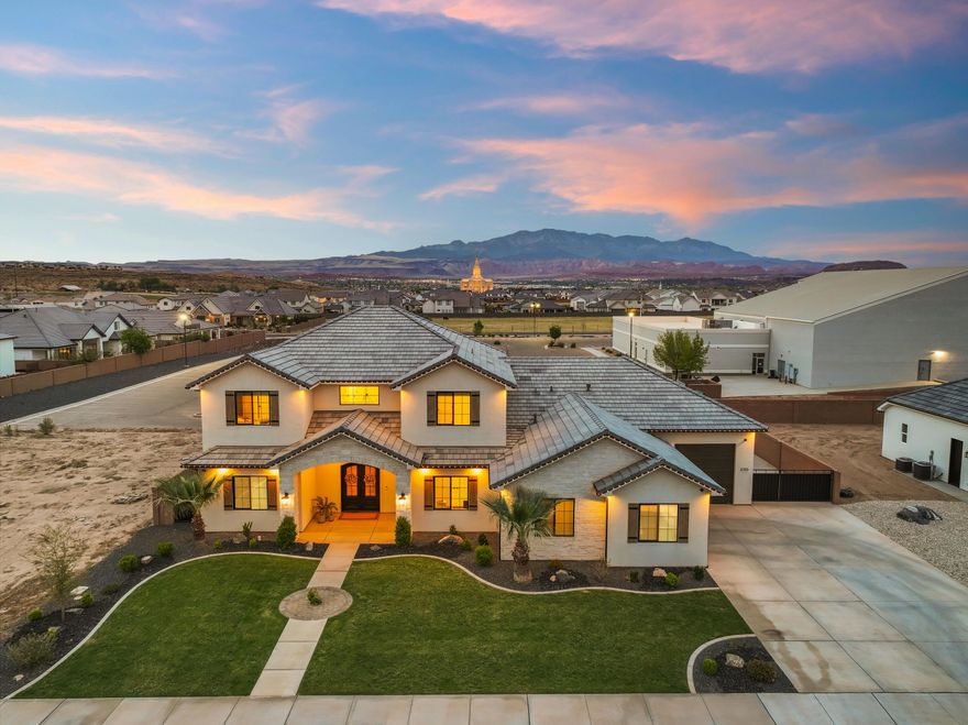 Experience this truly elegant and luxurious Saint George home, showcasing sweeping vistas of iconic red rocks and Pine Valley. A grand entry featuring 10' ceilings. This home features a bright, open layout bathed in natural light. The entertainer's kitchen boasts quartz counters, custom cabinetry, and a butler pantry, while a cozy fireplace and built-in speakers enhance the great room. Relish a second family area and a private theater—both with individual climate controls—for effortless hosting. Step outside to a covered deck with permanent lights and savor radiant desert sunsets or gather around the fire pit in the fully landscaped yard. Every inch exudes impeccable craftsmanship, delivering the ultimate retreat for refined living.