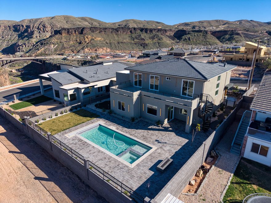 Experience elevated desert living in this exceptional luxury retreat overlooking the breathtaking landscapes of the Virgin River area and Zion mountains. Designed for both relaxation and entertaining, this stunning 6-bedroom, 3.5-bath home offers the perfect blend of elegance, privacy, and unforgettable views.

The heart of the home is a chef's gourmet kitchen featuring a dramatic waterfall island, premium Café appliances, custom cabinetry, and an open-concept layout that flows seamlessly into expansive living and dining spaces. Walls of windows frame the surrounding mountain scenery, bringing natural beauty into every corner of the home.

Upstairs, spacious bedrooms open directly onto a private deck where you can enjoy peaceful mornings and spectacular sunsets beside the enclosed outdoor fireplace--an ideal setting to unwind while taking in the panoramic landscape.

Step outside to your own private resort-style backyard. Enjoy the inground pool and hot tub, practice on your personal putting green, or entertain guests in the serene outdoor living spaces designed to capture the incredible views and tranquil surroundings.

Additional highlights include a rare RV garage, generous storage, and thoughtful design throughout that supports both luxury living and adventure.

With 6 bedrooms, 3.5 baths, and extraordinary indoor-outdoor amenities, this property offers a unique opportunity to own a private sanctuary with unmatched views and lifestyle just moments from the natural beauty of the Virgin River and Zion region.

Luxury. Privacy. Views. This is the one you've been waiting for.