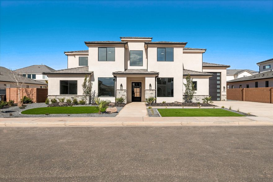 Every finish in this home has been thoughtfully curated to create a true custom feel. A stunning 3-sided fireplace and two sets of triple sliding doors seamlessly blend indoor and outdoor living. The primary suite is a showpiece, featuring a freestanding tub set within an expansive glass shower complete with dual heads & a hand wand. Custom cabinetry extends to the ceiling in the oversized closet, which also includes a 2nd laundry for ultimate convenience and storage. Every surface was designed to balance beauty & function. The 16' wide by 36.5' deep RV garage easily accommodates your toys, with additional exterior side parking. The backyard is graded & ready for your vision. Located in the Dixie Power grid, next to George Washington Academy & near Crimson High. Best of All - NO HOA!