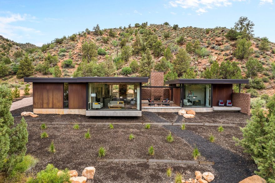 Desert modern architecture by award-winning Imbue Design meets the grandeur of Zion National Park in the Watchman Steel House. 

A striking exterior of rusting weathering steel blends effortlessly into the iron-rich landscape. The understated home boasts sandstone views that rival those from within the Park. 

A back patio provides a change of scenery and color with a hillside of conifers as backdrop. It is a quiet place to unwind, immerse in a good book or enjoy a warm soak after a day of hiking. Morning yoga is sublime. Or simply relax with your coffee and marvel at changing shadows cast across the West Temple by the rising sun in the east. Cozy and warm interior design is complemented by distinctive and beautiful Navajo furnishings. Predominately neutral tones inside allow the vibrant hues of the landscape to shine. 

A one bedroom casita has full kitchen and bath: you are able to host lucky family and friends while allowing downtime and privacy for all. Guests also have a small private patio and the premiere sunset views on Watchman Mountain. 

This is a one-of-a-kind property defying ordinary comparisons. A family vacation home for the generations, we welcome you for a visit to experience and to fully appreciate this special retreat.