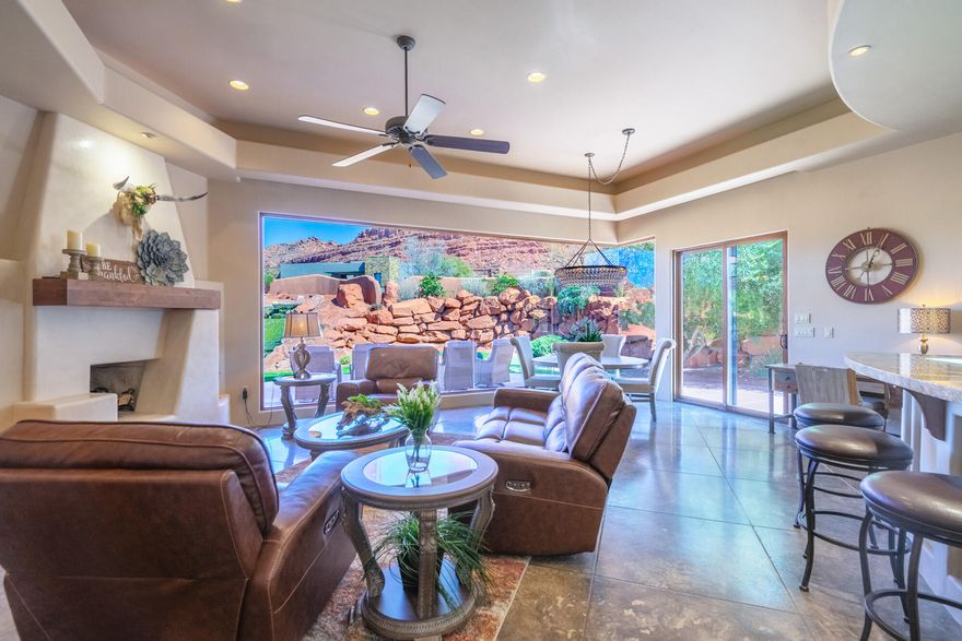 This exceptional 3-bedroom, 3-bath residence in the prestigious Kachina Springs community is ideally positioned to capture shaded afternoons and evenings--perfect for enjoying the patio and backyard throughout the year. A private, enclosed courtyard entry with striking wood beam accents sets a warm and welcoming tone.

Inside, stamped concrete flooring, dramatic floor-to-ceiling butted glass windows, and plantation shutters create a sophisticated yet inviting ambiance. The primary suite is a serene retreat, complete with a gas fireplace, direct patio access, a soaking tub, a spacious walk-in shower, and dual walk-in closets.

The open-concept kitchen is beautifully appointed with granite countertops, skylights, and premium built-in appliances including Sub-Zero, Wolf, and Fisher & Paykel. It flows seamlessly into the living area, where a cozy fireplace, custom plant shelving, and expansive backyard views create an ideal space for relaxing or entertaining.

Step outside to a thoughtfully designed patio featuring a built-in misting system, tranquil waterfall feature, and breathtaking red cliff views--an outdoor setting that truly elevates everyday living.

Additional highlights include a spacious 3-car garage equipped with a mini-split system and a central wet/dry vacuum, offering both comfort and convenience.

Residents can indulge in a wide range of clubs and activities including pickleball, tennis, swimming, yoga, and Pilates. Whether you're looking for outdoor adventures like hiking or exploring the fascinating beauty of the area, or simply want to enjoy a delicious meal at Sol Mesa or The Grille, Entrada has something for everyone. It's a place where you can easily make new friends and create lasting memories. It's important to note that all property owners in Entrada are required to become associate members of the country club, which includes a monthly fee of $220 and an annual food expense of $800 at the restaurant. Golf membership, however, is a separate cost.