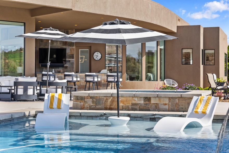 Absolutely stunning home in the gated community of the Ledges of Saint George with unobstructed views of the 16th fairway, and the beautiful white rocks of the Red Cliff National Conservation Area. Enjoy the surrounding striking views from almost every room through the tall panoramic windows. At the entrance, you are welcomed by a nicely secluded courtyard that leads into the home. The open floor concept combines elegant contemporary high-end finishes with timeless warm tones. The tall ceilings and windows allow you to soak in every single ray of light with the elegantly finished fireplace and entertainment center built-ins with wide ship plank backsplash. The wide LVP Hardwood floors lead you into the beautifully designed kitchen with quartz countertops, built-in refrigerator, double ovens, large pantry, floor-to-ceiling cabinets, large kitchen island with sink, contemporary high-end light fixtures, primary bedroom with tall windows, large walk-in shower with a soaking tub inside, and extra roomy closet. Other amazing features in the home include 4 spacious bedrooms including the casita, 4.5 bathrooms, separate office, 3 car garage with 1,159 SqFt of space, large laundry room, and all of this on 0.37 acres. Retreat to your very own exterior oasis with a great pool that features a shamu shelf, waterfall feature, fire feature, and spa. The recently completed outdoor kitchen features a built-in barbeque, bar area, and TV system. Enjoy the most breathtaking sunrises by your built-in fire pit or watch the sun glisten as it bathes the mountains to the east with its shine in the evening. There is no better way to stay cool in the warm summer than to have your yard facing the correct way. Furniture Package Available.

On the bench above Snow Canyon State Park, less than 15 minutes north of the city of Saint George. This property is also a short drive to some of America's most breathtaking destinations, including Zion National Park, Bryce National Park, and the north rim of the Grand Canyon. Other nearby state parks and national forests, include Sand Hollow Reservoir, Gunlock Reservoir, Quail Creek Reservoir, and Dixie National Forest that enhance the allure of the location. With over 300 days of sun, incredible year-round weather, and in the middle of a 7,200 yard par 72 golf course designed by Matt Dye, there is no doubt that The Ledges is one of Southern Utah's best kept secrets. One of the best places to live for those that love the outdoors, biking, hiking, fishing, ATVing, and all other high-desert adventures.

All information herein is deemed reliable but is not guaranteed. Buyer is responsible to verify all listing information, including square feet/acreage, to buyer's own satisfaction