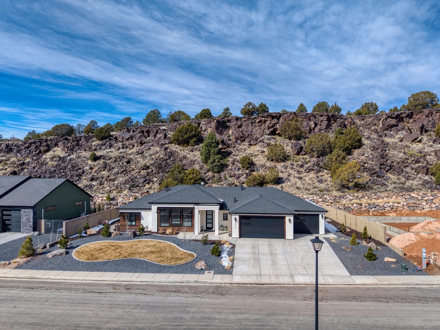 Tucked into The Canyon at Eagle Ridge, this newly built Alex Meisner custom home stands apart -- not just for its upgrades, but for the thought put into how it lives.
Set on .45 acres with no HOA and no backyard neighbors, the property backs directly to protected land featuring natural caves and historic relics along the ridgeline -- preserving both privacy and views you won't find replicated elsewhere.
Inside, the home feels complete from day one. Carefully chosen wallpaper and accent walls add warmth and personality throughout, while the kitchen anchors the space with high-end appliances and a bold color palette that makes the home feel inviting rather than staged. Natural light fills the 3 bed, 2 bath, 2,172 sq ft layout, creating a bright and comfortable living environment.
The primary suite was designed as a retreat, featuring heated bathroom floors, while the entire home includes window coverings already installed and a water softener in place -- details often overlooked in new construction but immediately appreciated in daily living.
Outside is where the property truly shines. A fully extended patio expands the living space into the backyard, framed by privacy walls on both sides of the property. Black metal awnings add architectural character and a custom finish that sets the home apart, while full paver work and landscaping complete the outdoor experience.
Located in one of Cedar City's most welcoming neighborhoods, this isn't just a new build -- it's a finished home.
Don't miss your chance to own a slice of The Canyon at Eagle Ridge.