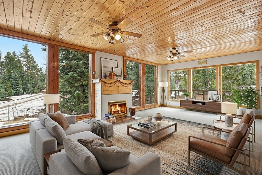 This stunning 2,706-square-foot, three-level cabin sits on just under half an acre and offers 3 bedrooms and 2.5 bathrooms in a thoughtfully designed layout. The main level features a spacious open floor plan filled with natural light from expansive windows and multiple access points to the deck—perfect for seamless indoor-outdoor living. You'll also find a convenient half bath, a beautifully modern kitchen with a walk-in pantry, and a nearby laundry room with ample storage. The upper level serves as a private primary suite, complete with a generous walk-in closet and a large ensuite bath, all surrounded by windows that create a bright, serene retreat. Downstairs, the basement level includes two additional bedrooms and a full bathroom, ideal for guests or family. Step outside to enjoy the covered deck and a spacious lot with plenty of room for a firepit and entertaining - an ideal setting for gatherings and making lasting memories.