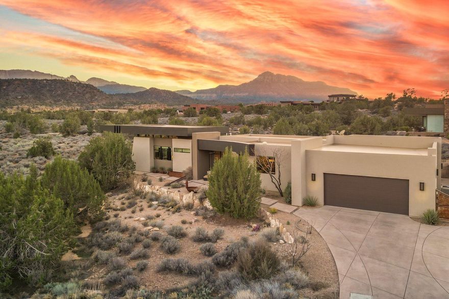 Located in the highly desirable Anasazi Plateau neighborhood just minutes from Zion National Park, this Burke Cartwright-designed home transforms the rugged Utah landscape into a private gallery. Every inch of this modern sanctuary is designed to honor its surroundings, with massive panes of glass framing iconic vistas of the West Temple and Kinesava red cliffs like living works of art. The interior radiates effortless warmth, anchored by light-toned engineered wood floors and an open-concept layout that flows naturally toward a sleek gas fireplace. Retreat to the primary suite to find your own gateway to the high desert, where a private backyard offers front-row seats to the glow of Eagles Crag. For guests or creative endeavors, the second bedroom functions as a self-contained suite featuring a built-in coffee bar, sink, and mini-fridge. Additionally, the oversized two-car garage goes beyond utility, offering a spacious workspace ideal for a professional studio or specialized storage. Rare, refined, and captivatingthis is Zion living at its peak. Proof of funds required prior to showing.