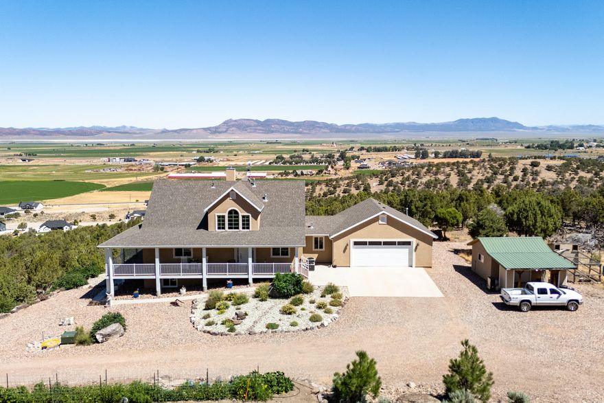 Stunning 4,982 sqft hillside home on 5 acres in a tranquil rural community! This 7-bed, 4-bath retreat with a private road boasts breathtaking views. All seven large bedrooms exceed standard sizes for comfort. The walkout basement apartment (2 Bedroom, 1 Bath) with separate entrance and kitchen is ideal for large families, guests, or multigenerational living. The main floor features a custom kitchen with knotty alder cabinets, granite cabinets, double ovens, and a tile backsplash. Enjoy hardwood floors, a wood stove in the vaulted-ceiling living room, and an 8 ft wide Trex deck that wraps around the entire living area. Lush landscaping, a large vegetable garden, and fruit trees enhance the property. Includes an oversized garage with an attached office/man cave, a pole barn (26'X34'').... RV parking and hook-up, and a detached heated/cooled shop. This home is where luxury meets rural charm!