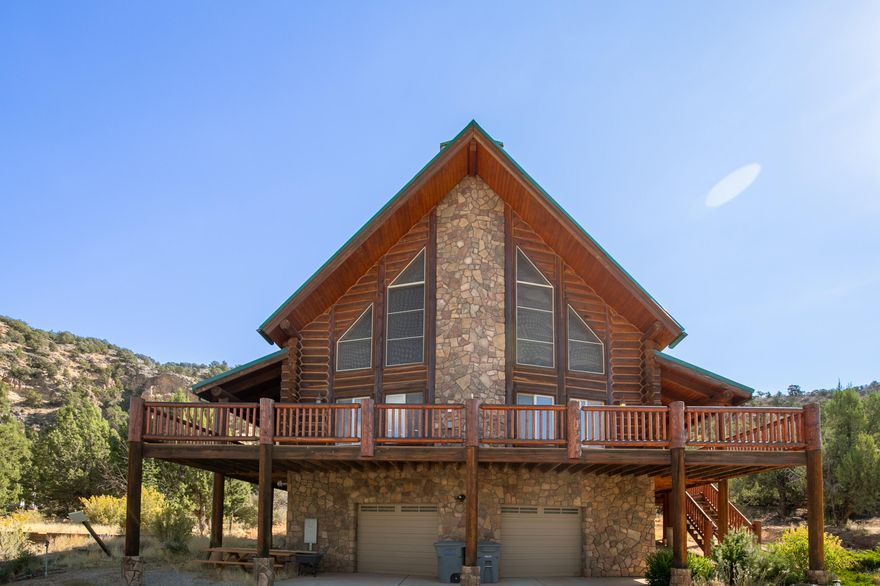 Priced to sell!! Welcome to your serene retreat in Harmony Ridge! This stunning log cabin, nestled on 1.16 acres, offers 3 bedrooms and 2 full bathrooms, thoughtfully designed for comfort and relaxation. Spanning 3,743 sq ft, the home features a main-level master bedroom complete with an ensuite bathroom, ensuring privacy and convenience. Upstairs, two spacious bedrooms invite you to unwind, each with access to a charming balcony that overlooks the lush surroundings. Large windows on the main floor flood the living area with natural light, creating a warm and inviting atmosphere. The property also includes a unique basement accessible from the garage, featuring an additional room and bathroom—perfect for guests or as a personal retreat.