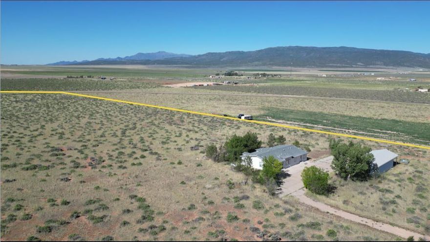 Almost 20 acres with 4 car garage/workshop with opener and attached high carport, and a 5 bedroom manufactured home that can be converted to an office. Property is in process of being re-zoned commercial. Close to I-15. Property has 1 acre foot of underground water #73-3142 in existing private well. Home was recently repainted inside and out; new flooring installed throughout the home; re-shingled; new A/C (forced air). Detached garage to be repainted inside.