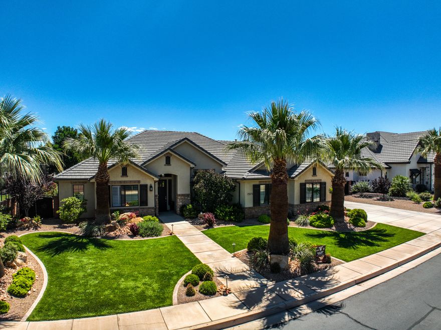 Luxury and casual living can coexist. This custom-appointed 5-bedroom, 3-bathroom home is zoned for Crimson View schools and offers all the quality upgrades you'd expect. High-end custom finishes, coffered ceilings, plantation shutters, striking contrasting cabinetry, and elegant quartz countertops are complemented by a spacious pantry, ample storage, and generously sized closets. Curb appeal begins the moment you arrive, with a yard framed by palm trees inviting you to the entry. The great room and the open-concept kitchen and dining area flow seamlessly for gatherings, whether it's game day with friends or a formal dinner service. The backyard is private and lush, a perfect retreat. Need garage space? The 4-car garage with sealed floors provides abundant room to protect and secure all your vehicles and gear. Call to view today! Located in Bridle Gate Estates, Little Valley, Bridle Gate offers exclusive equestrian privileges within the community and convenient access to almost everything in greater St George.
