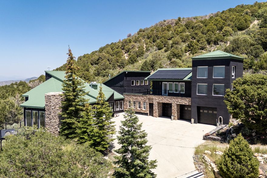 Prepare to be amazed! Three elements of good design are the use of space, light and air, all of which are on display in this beautiful home called the ''Aerie''. Suspended high above the city on the rim of Cedar Highlands, with crystal clear air and 360 degree views. This home is more unique and modern, than other homes in the area. Every angle of its design is a masterpiece of art, with a panoramic view from any window. When you walk into the custom front door, you are surrounded by large windows, through which the view and light pour in. Step out to the surrounding deck, to gaze upon the city and distant mountain areas. Nestled up against BLM forest land you can observe nature while in your hot tub as deer slowly walk by and squirrel run on the rocks, in the natural landscaping including extensive beds of lavender that surround the property. The home has solar panels installed that are already paid for. This Fortress on top of the hill is well appointed with quality custom features and high end European appliances. A guest quarter attached but separate from the home, has two bedrooms, 1 bathroom, kitchen and a lovely screened in porch for summer nights. Gourmet kitchen and a sunroom with heated floors. Master Suite has a loft study or reading lounge. Above the grand room is a private office with its own balcony, with view. This home is for the buyer that wants a get-a-way, who loves to entertain, who appreciates good design. It is truly a unique place floating above the city.