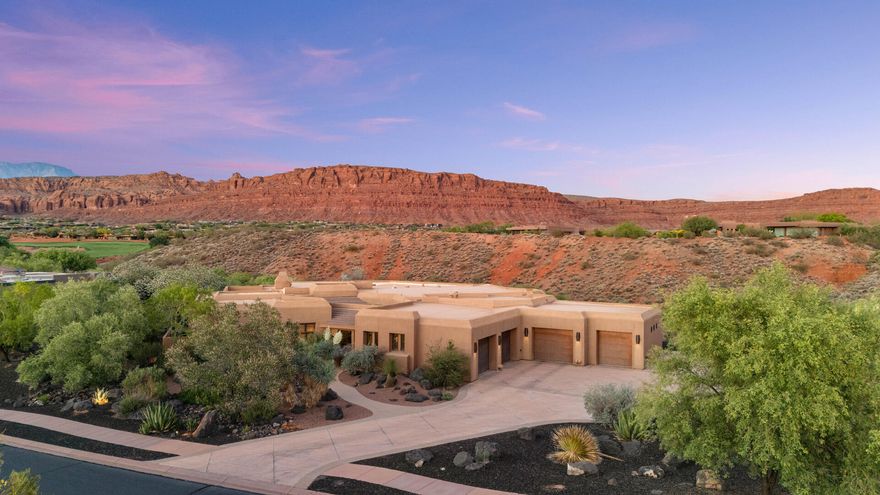 You know that feeling when a place immediately slows your heartbeat a little?
That's this home.
You walk through the private front courtyard, open the front door, and before you notice a single finish or detail inside, your eyes go straight through the wall of windows to the red rock cliffs beyond. It's the kind of view that stops conversations mid-sentence. The kind that made the current owners say yes the moment they stepped inside.
Set on .69 acres within the gates of Entrada, the home was carefully positioned to create an incredible sense of privacy. Instead of looking into neighboring homes, nearly every angle frames desert landscape, golf course, lava rock, and open sky. Hawks drift overhead. Hummingbirds move through the courtyard. At night, it becomes quiet in a way that's hard to find this close to the city.
And yet, you're not removed from life, you're right in the middle of one of Southern Utah's most sought-after communities. Golf, dining, and the Entrada clubhouse are just moments from your door, while the energy of St. George sits right outside the gates when you want it.
The layout balances comfort, flexibility, and hospitality beautifully. The casita with its own kitchenette gives guests a stay that feels private and elevated. A dedicated theater creates the perfect escape for movie nights and game days, while the flex room off the garage can easily become a gym, studio, hobby space, or additional storage for an active lifestyle.
With 3 bedrooms, 3.5 baths, unforgettable views in every direction, and a setting that feels connected to nature without sacrificing convenience, this is more than a home, it's the experience people hope for when they imagine living in Entrada. Beyond the views and architecture, what makes this home special is the way it lives day to day. Every space was designed to feel connected to the outdoors, the surrounding desert landscape, and the people inside it.
Set on .69 acres within the gates of Entrada, the home was carefully positioned to create remarkable privacy while still capturing panoramic views of the golf course, lava rock, desert plantings, and towering red cliffs in nearly every direction. The low profile Southwestern architecture blends naturally into the landscape with warm stone, rich wood details, and soft rounded lines that feel timeless and authentic to Southern Utah.
Arrival at the home feels intentional from the very beginning. A private iron gate leads into a beautifully landscaped courtyard filled with mature desert plants, shaded trees, and the quiet sound of wind chimes moving gently through the air. The courtyard creates a peaceful outdoor gathering space while providing convenient access to the casita, garage, powder bath hallway, and the custom wood front entry door.
Then comes the moment that defines the home.
As you step through the front door, your eyes are immediately drawn through the expansive windows of the great room to the red cliffs rising beyond the backyard. Natural light pours into the main living spaces, highlighting the soft architectural details, exposed beams, handcrafted finishes, and warm textures throughout the home. Rounded walls, tray ceilings with integrated lighting, custom woodwork, and carefully selected materials create a feeling that is elevated yet comfortable and never overdone.
The open concept floor plan was designed for effortless living and entertaining. The great room flows naturally into the dining area and kitchen, creating connected spaces that feel open while still warm and inviting. Large windows throughout keep the surrounding scenery constantly present, making the desert landscape feel like part of the interior experience.
The kitchen combines craftsmanship with functionality, featuring rich solid wood cabinetry, handcrafted hardware, granite countertops, under cabinet lighting, double Thermador refrigerators, double ovens, and generous prep space throughout. An oversized butler's pantry adds even more storage, countertop space, and a secondary sink to support entertaining and everyday convenience. Thoughtful features like the built in central vacuum system, intercom, and whole home speaker system reflect the attention to detail carried throughout the property.
Adjacent to the kitchen, the spacious laundry and utility room functions as far more than a traditional laundry space. Extensive cabinetry, large countertops, a built in desk area, sink, custom storage solutions, and direct access to both the garage and primary closet create incredible flexibility for hobbies, organization, crafts, or additional workspace.
The primary suite was designed as a private retreat with large windows framing the surrounding scenery, a fireplace for warmth and ambiance, and direct access to the covered patio. A sitting area positioned near the windows creates the perfect place to enjoy the peaceful desert surroundings throughout the day. The primary bathroom offers generous space and functionality with dual vanities, a makeup and desk area, a jetted soaking tub, oversized walk in tile shower, abundant storage, separate toilet room, and a private sauna for a true spa like experience at home. The expansive primary closet includes extensive built ins, custom storage, a large dresser style folding area, and direct connections to both the bathroom and laundry room for everyday convenience.
The guest suite was equally well designed, featuring built in bookcases, a fireplace, large windows, direct patio access, built in desk space, extensive storage, and a spacious en suite bathroom with a large walk in tile shower. Whether hosting guests or creating additional workspace, the room offers comfort, privacy, and flexibility.
At the end of the hallway, the dedicated theater room creates an immersive entertainment experience with tiered seating, integrated speakers, detailed ceiling treatments, and updated Sony equipment. The space also functions beautifully as a media room or game room while remaining tucked away from the main living areas for privacy and quiet.
The detached casita adds even more versatility to the property with its own private entrance, built in bookcases, kitchenette, dining area, walk in tile shower, and comfortable living space. Whether used for guests, multigenerational living, a home office, or a private creative workspace, the casita offers flexibility without sacrificing comfort or privacy.
An additional flex room located off the breezeway connecting the garages provides bonus space for a home gym, studio, hobby room, office, or future guest suite. With a mirrored wall, carpeted flooring, and plumbing already stubbed in, the room is ready to adapt to a variety of future needs.
Outdoor living is equally impressive. Expansive covered patios overlook mature desert landscaping filled with sculptural cacti, flowering plants, lush greenery, natural lava rock, and layered stonework that blend seamlessly into the surrounding terrain. Winding pathways, shaded seating areas, and open views create outdoor spaces that feel peaceful, private, and deeply connected to nature. A raised garden grow box offers space for herbs, vegetables, or seasonal flowers, while hawks, hummingbirds, and other desert wildlife become part of daily life around the property.
The oversized four car garage features epoxy floors, excellent lighting, organized storage systems, and a split layout with a separate single car bay for additional flexibility. A dedicated utility room allows easy access to HVAC and maintenance systems while keeping them tucked discreetly away from the outdoor living areas.
Inside Entrada, residents enjoy one of the most visually stunning gated communities in Southern Utah, with golf, dining, clubhouse amenities, and scenic beauty all located just moments from the home itself. While the property feels immersed in nature and removed from the pace of the city, the conveniences of St. George remain just outside the gates.
This is the kind of home that changes how everyday life feels, where the scenery becomes part of your routine, the outdoor spaces invite you to slow down, and every detail was designed to create comfort, beauty, and connection to the landscape around it.