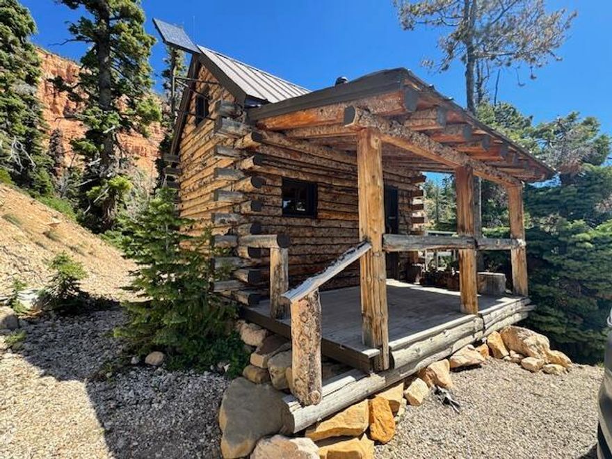 Tucked away in the tranquil woods of Navajo Lake Estates, this rustic cabin offers a peaceful escape from the hustle & bustle of everyday life. Perched on two spacious lots & surrounded by nature's quiet beauty, this charming retreat feels like a secret hideaway where time slows down & the views take your breath away. From the moment you arrive, you'll be captivated by the red cliffs in the distance, their vibrant hues echoing the majesty of a miniature Bryce Canyon. Whether you're enjoying a morning breeze on the quaint front porch or watching the sun set from the back deck, this is a place where serenity reigns & star gazing can become your new hobby.  Inside, the warm glow of the Jøtul cast iron wood stove invites you to curl up & unwind. The cabin is thoughtfully designed for off-grid living, powered by solar energy & equipped with propane appliances to keep things simple yet comfortable. Though there's no running water, a natural spring just down the road offers a steady, reliable source for your water needs yet another reminder of how beautifully self-sufficient this place can be. Bordering the vast Dixie National Forest, the property feels secluded & private, making it the perfect summer retreat or seasonal getaway. With an additional lot available, the possibilities for expansion or added privacy are endless. Whether you're seeking a quiet refuge, a base for outdoor adventures, or simply a place to breathe deeply & reconnect with the land, this cozy cabin in the woods offers it all. It's more than just a property it's a lifestyle, and a chance to own your own little piece of paradise.  

Additional adjacent 1/2-acre lot #38 available for a purchase for $169,900.00 for all 3. SID is per lot per year (lots can possibly be combined to reduce fee)