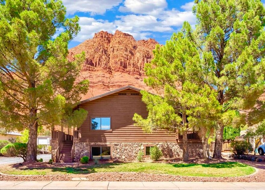 BREATHTAKING VIEW of RED MOUNTAIN. Just steps from Hiking/Biking Trail. ADU w/separate entrance & ample parking...rental possibility! 3,000 SF, 5 bd, 4 ba, 2 decks. Well built solid log home. Spacious great room, stone fireplace & vaulted ceilings. ADU; 2 bed, 2 bath, kitchen. Upper level; 3 bed, 2 baths, spacious master w/ 2 large closets & oversize master bath. 2 distinct living spaces but can easily be converted back to single family. 2 RV parking areas, each w/ own hookups. **NEW '24 Updates: Metal Roof, A/C, Furnace, Epoxy Garage Floor, Carpet, Counters & Backsplash.** 2.5 car garage w/ 3 doors for easy access. No HOA! Low-maintenance yard! Clean, beautiful home IN THE HEART OF IVINS. Minutes to Snow Canyon State Park. Listing agent related to seller. Seller is a licensed agent.