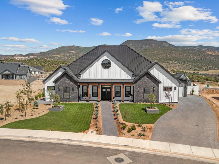 Welcome to your dream home in the highly sought-after Saddleback Ridge neighborhood of Cedar City, Utah. Perched on an elevated 0.49-acre lot, this exquisite custom residence offers breathtaking panoramic views—arguably the best Cedar City has to offer. Thoughtfully designed and impeccably crafted, this is not your average home.
Step outside to a sprawling 500 sq. ft. patio, complete with elegant pavers, a built-in outdoor kitchen, and a wood-fired pizza oven—the ultimate space for entertaining or simply soaking in the sunset over the valley. The fully landscaped yard is a peaceful retreat, enhanced by a greenhouse complete with water hookups and power to provide heat in the winter and a dedicated storage shed for added convenience. Inside, the home features a spacious great room and kitchen area with vaulted ceilings, showcasing attention to detail at every turn. From crown moldings and oversized baseboards to built-in cabinetry and a hidden walk-in pantry, no element was overlooked. The kitchen is equipped with high-end appliances and top-of-the-line plumbing fixtures, ideal for those who love to cook and entertain.
Finished with a durable and stylish metal roof, this home combines timeless beauty with low-maintenance living. Skip the stress and delays of buildingthis truly unique property is move-in ready and waiting for someone who appreciates craftsmanship and comfort.