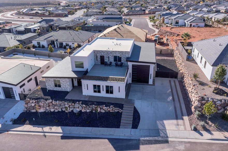 Architectural modernism rises in the Red Cliffs of Washington with amazing pool/hot tub, ADU apartment, and RV garage with full hookups— 3,806 sq ft unfold through light-driven volumes, polished surfaces, and a commanding kitchen with double ovens, built-in range, and full pantry. The primary suite is composed with spa-grade detailing and a generous dressing area. Outdoors, a heated pool, spa, and concrete patio frame the red-rock horizon. Oversized tandem garage with RV separate HVAC unit and additional exterior RV parking.  Buyer to verify all information.