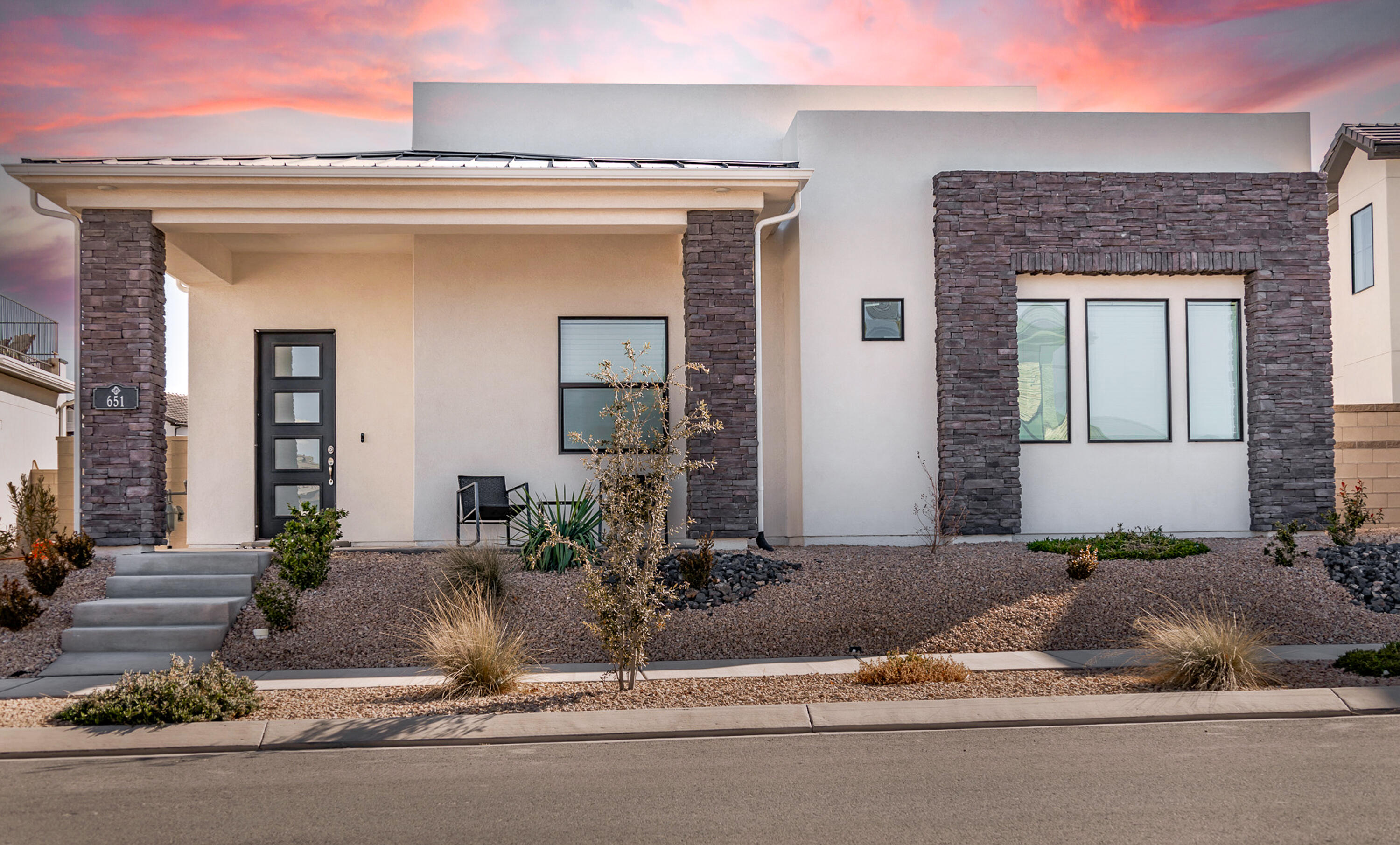 Modern design meets comfort in this stylish home on a premium lot in Desert Color's Sage Haven. The bright, open layout features a sleek kitchen with stainless steel appliances, quartz countertops, a large pantry, and select kitchenware included. The primary suite boasts dual walk-in closets and a spacious shower, while two additional bedrooms also offer walk-in closets.  Thoughtful upgrades include a built-in sound system, water softener, epoxy garage floor with overhead storage, and soft-close cabinets. Low-maintenance desert landscaping enhances the home's appeal. Select furnishings may be included with an acceptable offer, making this an effortless move-in opportunity. Enjoy access to parks, trails, a prep academy, seasonal events, a 10-foot-deep lagoon, and a year-round heated pool and jacuzzi. Conveniently located near BigShots, SGU Airport, and upcoming shops and dining.