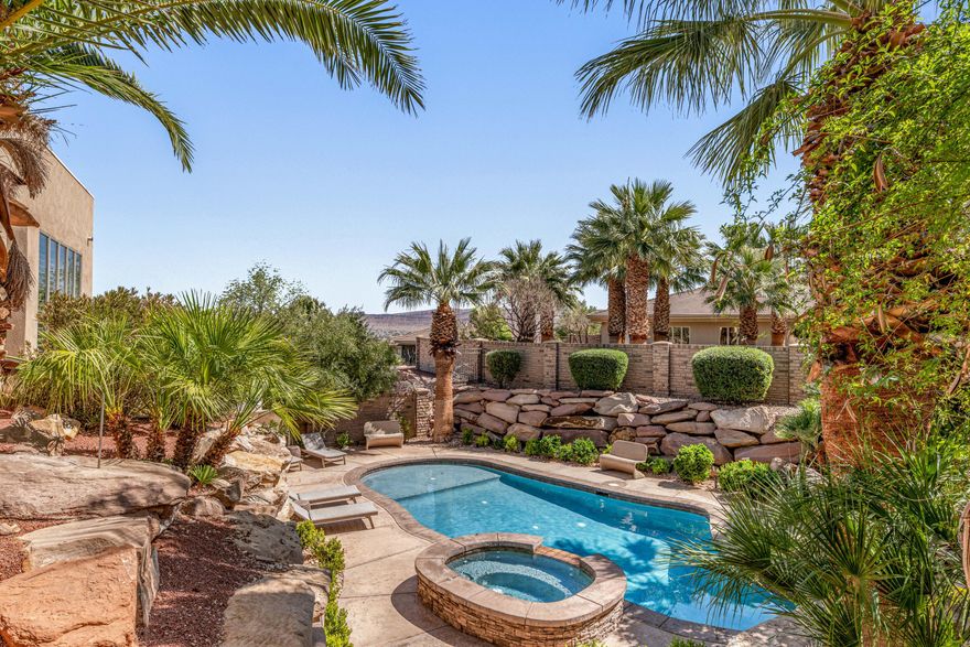 Tucked within the gated community of Stone Cliff, this residence offers timeless design and effortless livability--set against some of St. George's most iconic red rock views. Grounded in natural materials and classic finishes, the home carries a sense of quiet elegance and warmth. Thoughtfully scaled spaces are filled with natural light, and the surrounding desert landscape feels present in nearly every room--framed, not just glimpsed. The main level is made for gathering. Multiple patios extend off the kitchen for seamless indoor-outdoor living, while a canopy of mature trees creates the kind of shaded backyard that's equally at home hosting a dinner party or a holiday card photoshoot. The primary suite functions as a true retreat--complete with a sitting area where you can unwind with a book or simply take in the elevated views over the pool and landscape below. Downstairs, the walkout level opens directly to the pool, finished with a sun shelf, spa, and water feature. The space is flexible enough for recreation, hosting guests, or multi-generational living, and a dedicated poolside room adds the kind of practical convenience that makes everyday life easier. A craft room sits adjacent to the laundry, and a workshop connects to the fourth garage--room for hobbies, projects, or whatever you've been meaning to get to. Offered turnkey with furnishings included, this move-in-ready home works equally well as a primary residence or a second-home retreat.
Stone Cliff is one of St. George's most sought-after communities--private, well appointed amenities, and close to the outdoor recreation that defines life here.