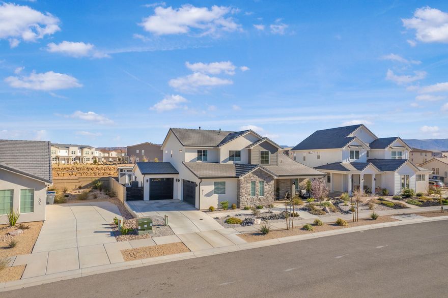Welcome to this beautifully upgraded home in the sought-after Desert Color resort community in St. George, Utah--known for its stunning lagoon, resort-style amenities, and vibrant lifestyle. This thoughtfully designed home blends modern finishes, functional spaces, and seamless indoor-outdoor living.

The main level features engineered European White Oak hardwood floors and an electric fireplace with designer tile that anchors the open-concept great room. Large windows bring in abundant natural light and include Lutron-controlled custom blinds, while top-down/bottom-up cellular shades provide privacy and flexibility. Stained wood and metal stair railings add warmth and character, while floating vanities and Moen chrome fixtures elevate the bathrooms.

The kitchen features floor-to-ceiling cabinetry, quartz countertops with a waterfall island, GE appliances, soft-close drawers, pull-out shelving, under-cabinet lighting, a double sink, and a spacious pantry with outlets. An 8-foot sliding glass door opens to the covered patio, creating the perfect space for entertaining and outdoor dining.

The primary suite offers a peaceful retreat with a sliding glass door leading to a pergola-covered patio with privacy screens. The spa-style bathroom includes an 8-foot tiled shower with a rain shower head, floating double vanity, custom closet system, and stackable washer/dryer hookup.

Upstairs features 3 bedrooms with mountain views, a full bathroom with updated tile, a cast iron tub, an upgraded laundry room with cabinetry, and a cozy loft space.

Additional highlights include an epoxy garage floor, hanging storage racks, water softener, and a climate-controlled studio shed with a mini split, LVP flooring, ceiling fan, and custom blinds.

Residents enjoy the iconic 2.5-acre lagoon, white sand beaches, pools, pickleball courts, parks, trails, and year-round community events--just minutes from Snow Canyon and Zion National Park.