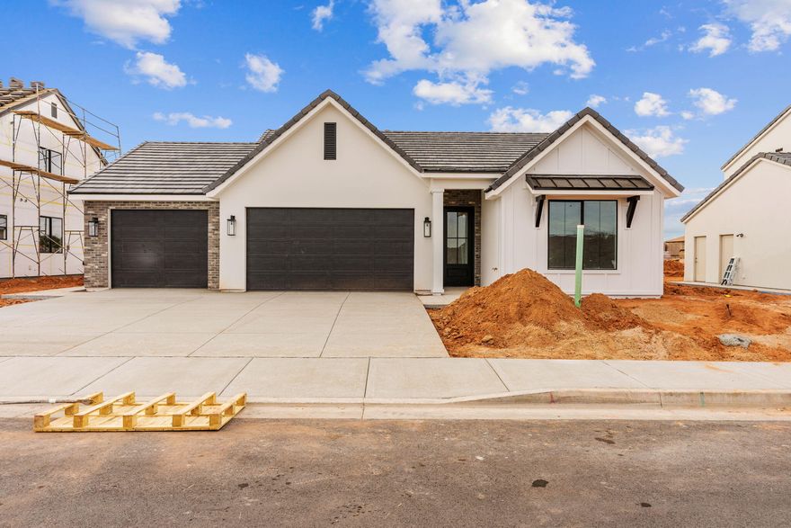 Welcome to the Zinnia floor plan in beautiful Santa Clara, UT — a thoughtfully designed 3-bedroom, 2-bath home offering 1,639 sq ft and an oversized 3-car garage. Built with transparent pricing and designer finishes included, this home delivers elevated quality without surprise upgrade costs. Features include an upgraded front door, enhanced stone with smooth stucco accents, black-framed double-pane windows, and upgraded lighting throughout. The gourmet kitchen offers upgraded appliances and microwave, 42'' upper cabinets, laundry cabinetry, tile showers, upgraded flooring and carpet, and custom closet shelving with walk-in closets. Fully finished landscaping with rear and side block walls. Located near Black Desert Resort, Harmons, and Gubler Park.