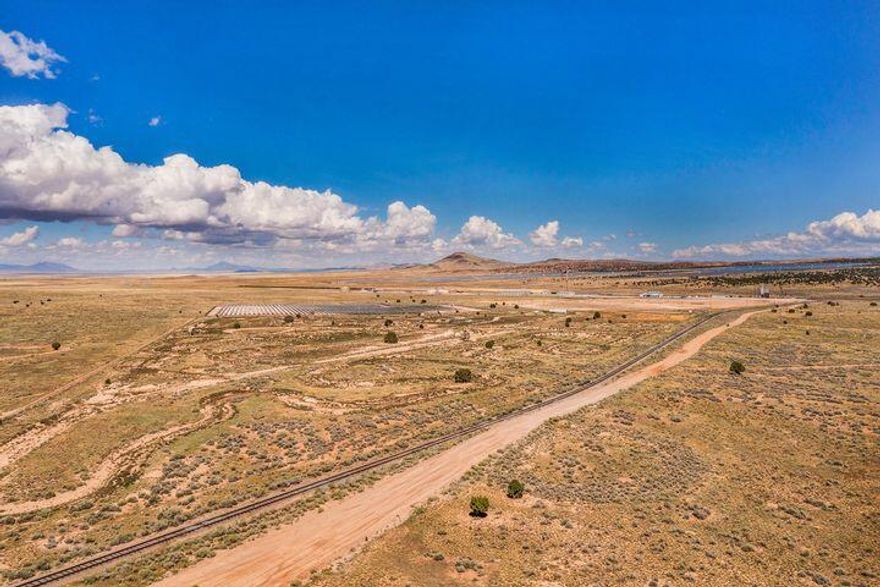 Rare opportunity to secure 51.46 acres of prime commercial land with direct highway access and 2 acre-feet of water rights. The property features a full motocross track, multiple usable structures, and 8 RV hookups already in place. Bordering a railroad, it offers outstanding versatility for recreation, events, or future commercial development. A unique property with endless potential! Buyer/buyer agent is responsible for verifying all information.