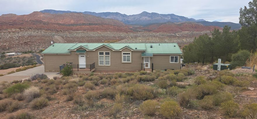 Experience elevated living in this beautifully maintained manufactured home, perched on the premier view lot in Silver Valley Estates. Set atop one of Leeds' highest points, this property showcases breathtaking panoramic views of Pine Valley Mountain and the surrounding red rock landscape. Enjoy peaceful mornings and colorful sunsets from the newly reconstructed Trex deck, and the freshly painted exterior gives it a crisp, welcoming look. Sitting on a spacious 1.03-acre lot, there's plenty of room to add a garage or additional structures—offering both comfort and opportunity in one remarkable location.