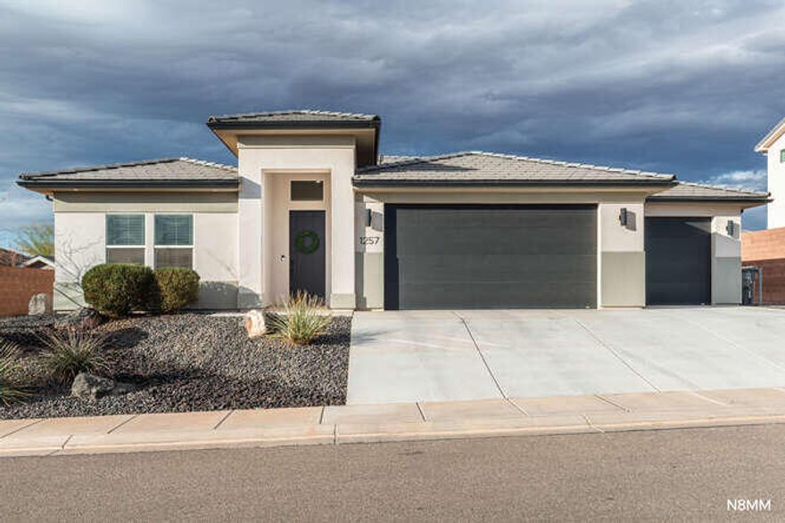 Just listed--and already turning heads. This nearly new home blends modern design, smart layout, and one feature buyers are constantly searching for but rarely find a 4 car garage in this price point. Whether you have toys, tools, hobbies, or just love extra space, this is a game-changer.

Inside, the open great room floor plan creates a bright, welcoming space perfect for entertaining or everyday living. The primary suite is tucked privately from the other 2 bedrooms, offering privacy and comfort for everyone.

The exterior delivers instant curb appeal with sleek modern elevations and a desert-scape front yard. for easy maintenance. The backyard is a blank canvas--ready for a pool, outdoor kitchen, play area, or your dream backyard retreat. Located in Warner Gateway with its own neighborhood community pool. A brief 2-3 minute walk to Crimson Cliffs schools, and powered by Dixie Power, known for its lowest electric costs in Utah. This home is as practical as it is impressive.