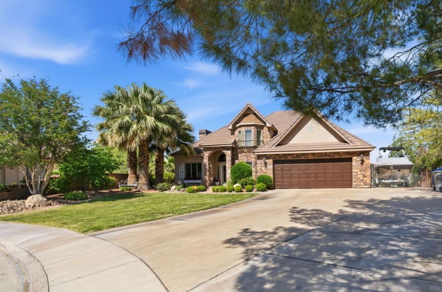 Nestled on a private .39 acre lot in scenic St George, this storybook home offers a perfect balance of convenience and tranquility -just minutes away from everything you would need, dining, shopping, banking, gym and everyday amenities, while still feeling tucked away in a private and peaceful cul-de-sac. This beautifully remodeled 4200 sq ft home features 4 bedrooms and 4 bathrooms, 2 kitchens, 2 laundry rooms, dedicated office, loft, den, and formal dining. Updates throughout include new flooring, fresh paint, updated countertops, and new air conditioning units. Designed with versatility in mind, the home is ideal for  multi-generational living, an ADU set up, or rental income potential with NO HOA restrictions.  The cozy living areas are flooded with natural light.  Whether you are seeking a peaceful retreat or an entertainers dream, this home provides it all. Outside you will enjoy the breathtaking view of Snow Canyon, providing a tranquil and scenic back drop from  your private oasis,  including an inviting pool and hot tub, surrounded by mature palm trees.  You will enjoy endless RV parking for all your toys. The drive-thru RV makes it a haven for outdoor enthusiasts including a detached garage or workshop. Bring all your toys because this property has endless RV parking, with a drive thru RV that goes completely from one end of the property to the other.