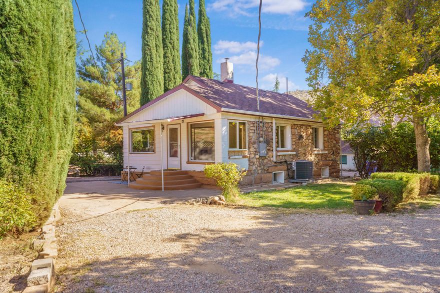Nestled beneath towering red rock cliffs and mature shade trees, this historic Rockville property captures the timeless beauty and tranquility of Zion Canyon living. 

The main home offers three bedrooms, three and a half bathrooms, a full kitchen plus two convenient kitchenettes—ideal for flexible living arrangements, guest quarters, or rental potential. With multiple separate entrances, the layout allows for excellent privacy and versatility. Large front windows fill the home with natural light and stunning views of Mount Kinesava.

A separate guest cottage in back provides a cozy studio complete with its own kitchen and bathroom. This legal Accessory Dwelling Unit (ADU) sits on a spacious, fully fenced grassy yard with ample parking—perfect for extended family, visitors, or rental income.

A utility room located in the back of the home features washer and dryer hookups, offering convenient access for all occupants. The property also features a new HVAC system for the main house and a mini-split for the cottage.

An irrigation water share is included, allowing you to easily maintain the lush landscaping, multiple fruit trees and to create your own garden beneath the shade of the mature trees.

Located in the heart of Rockville, just minutes from Zion National Park, this property offers a rare opportunity to own a piece of local history in one of Southern Utah's most scenic settings.

Short term rentals are not allowed.
Home is being sold as-is. All information is deemed reliable. Buyer to verify all details.