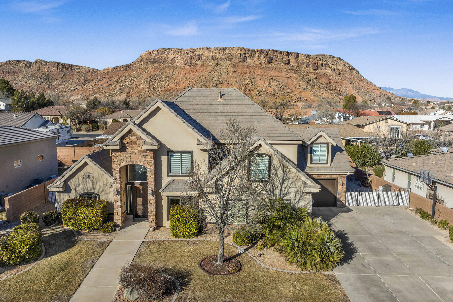 In one of Southern Utah's nicest subdivisions lies this beautiful 2 story home. Within a short proximity to the Bloomington Country Club and the Bear Claw Poppy trailhead, this stunning home offers a large primary bedroom with an ensuite bathroom, powder room, and an office on the main floor, 4 bedrooms and a large theater/flex room on the 2nd floor and 2 bathrooms including an ensuite. The home features a foyer with 18' ceilings, a great room with lots of windows, a gas fireplace and wonderfully designed kitchen. The gourmet kitchen has granite countertops, a hidden pantry, and knotty alder cabinets. The primary suite has beautiful tile floors, jetted tub, shower, double sink granite countertop, and a large walk-in closet. The upstairs space adds a well laid out open room to add an additional office or sitting area. With 4 spacious bedrooms including one with an ensuite, and a large theater/flex room perfect for entertaining large groups with stunning views of the mountain. The 3 car garage with built-ins offers solid room for your vehicles and ATV/UTV. The north facing outdoor space allows plenty of light, but also offers plenty of privacy and space. The large 21' Swim Spa is perfect to use throughout the year. Enjoy two spacious sheds to store all of your holiday décor.
The home is a short drive to the sheer massive cliff walls of Zion National Park, the hoodoos of Bryce Canyon National park, or the North Rim of The Grand Canyon. There is no place like it. Enjoy nearby hiking, biking, and outdoor adventures or any of the 4 amazing large reservoirs and thousands of recreational public acres for the adventurous at heart. The region is also known for its internationally renowned golf courses that recently hosted the PGA tournament and will soon host the LPGA. Saint George is also the host for many events such as the Ironman, Red Bull Rampage, and the Saint George Marathon. A 5-minute golf cart ride from this home gets you to Green Spring Golf Course, host of the Huntsman Senior Games Golf Championships.
 
All information provided is reliable but not guaranteed. The buyer is responsible for verifying all listing details, including square footage and acreage, to their own satisfaction.