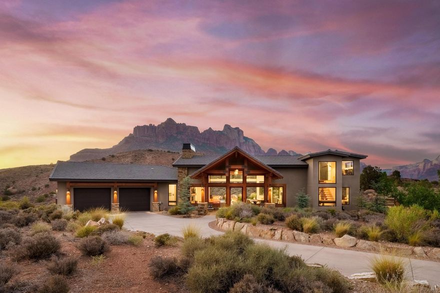 A Love Letter to the Desert :: 

Tucked high atop the Anasazi Plateau and just moments from the gates of Zion National Park, this architectural gem captures the heart and soul of the high Desert. Built in 2019, this extraordinary home is more than a residence—it's a retreat, a sanctuary, a place where timeless design meets the raw beauty of nature in perfect harmony.

Crafted in a modern desert style and wrapped in the warmth of Big Cedar timber and native stone, this home evokes the cozy romance of a mountain cabin while remaining bold, clean, and contemporary. As you approach the entry, the scent of cedar greets you—an invitation to leave the ordinary behind. Through oversized commercial glass doors, you enter a space where walls of windows dissolve boundaries and the glowing cliffs of Zion become part of the room.

Inside, a soft, neutral palette lets the landscape take center stage. Every corner has been curated for both comfort and beauty from the statement fireplace wall in the great room to the European-style kitchen adorned with high-end appliances. Here, life flows effortlessly between indoors and out. Four massive 10' sliding pocket doors open to a professionally designed outdoor terrace, where you can dine, entertain, or simply sit in stillness under Springdale's famously brilliant night sky.

Two elegant en-suite master bedrooms on the main level offer complete serenity, each with spa-like bathrooms and spacious walk-in closets. A third bedroom and bath, a designer powder room, a sleek hardwood dining table, and a cozy coat nook provide thoughtful touches throughout. Even the butler's pantry tells a story with built-in workspace, wine fridge, and function wrapped in style.

And when you step into the oversized garage, you'll find not just space for your vehicles, but a workbench, storage, and even a custom dog-wash station for your four-legged companions.
Surrounded by conservation land, this home offers unmatched privacy and silence. No rooftops. No distractions. Only the changing light on the cliffs, the stillness of dusk, the breeze through native trees. From sunrise hikes to sunset dinners, this is a place to reconnect with nature, with yourself, and with those you love.

Just minutes from Zion, and a short scenic drive to Bryce Canyon, the North Rim of the Grand Canyon, Snow Canyon, Tuacahn Amphitheatre, and the vibrant town of St. George, this home is both a private escape and a gateway to adventure.

There are homes and then there are places that live in your soul.
This is one of them.