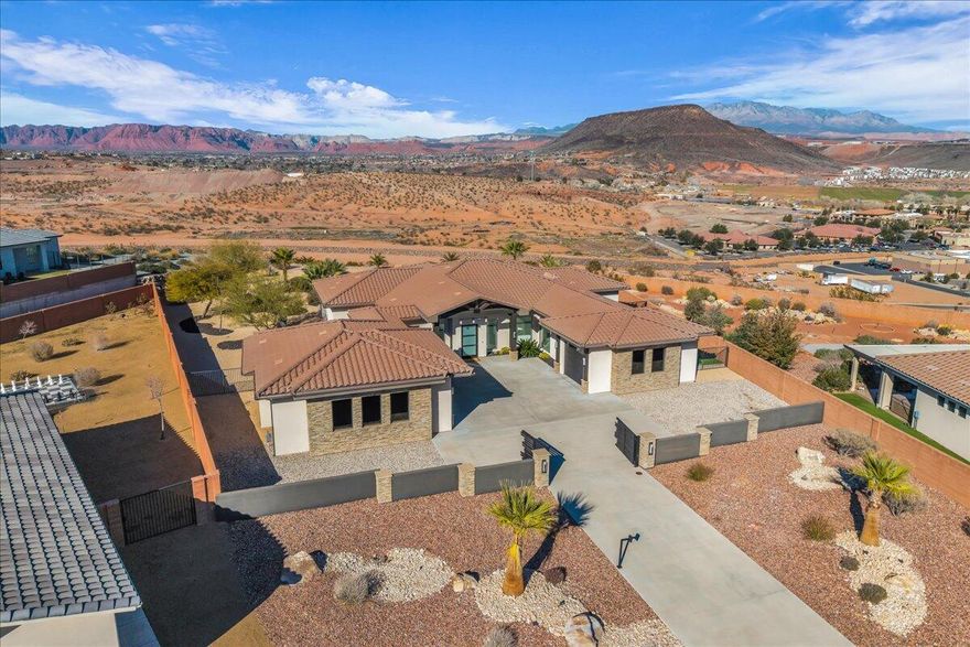This striking modern residence delivers jaw-dropping, 180-degree unobstructed views of Red Mountain, Snow Canyon, and Green Valley—forever views that stop you in your tracks. Set on a large ledge-view lot, the home offers rare privacy and security, complete with a private gated entry and a full home security system with cameras, creating an exclusive retreat above it all.

Designed for those who want the best of everything, this home is made for entertaining, recharging, and showing off. Indoor and outdoor living blend effortlessly, turning every gathering into an experience. The private saltwater pool is pure resort energy, featuring in-water loungers, umbrella sleeves, and a swim-up bar, alongside a separate spa and gas fire pit—all framed by epic, unobstructed v views that beg to be photographed.

Inside, every detail is intentional and elevated. A five-zone Sonos sound system sets the vibe, while a new top-of-the-line Infinity Series HVAC system with mini-splits delivers instant, efficient cooling throughout the home and garages. The kitchen stuns with hand-milled cabinetry, new high-end appliances, and a sleek wine coolerperfect for post-golf evenings or hosting unforgettable nights.

The layout is ideal for a single couple or discerning owner who values space, style, and impact, featuring two luxurious primary suites and a dedicated office/den. Double garages accommodate four cars plus toys, finished with custom floors worthy of the collection they house. High energy efficiency, a private patio, and refined modern finishes complete the experience.

This is not just a homeit's a statement. Built for someone who lives actively, trains hard, plays hard, loves golf, fitness, and design, and demands Instagram-worthy views, total privacy, and undeniable presence. Bold. Exclusive. Unapologetically stunning.
This exceptional modern residence offers commanding 180-degree unobstructed views of Red Mountain, Snow Canyon, and Green Valleyforever-protected vistas that rival the finest view homes in premier luxury markets. Positioned on a rare ledge-view lot, the property delivers complete privacy, security, and elevation above it all, featuring a private gated entry and a comprehensive home security system with cameras.

Designed for high-performance living and effortless entertaining, the home creates a seamless indoor-outdoor lifestyle where architecture and landscape merge. The resort-style saltwater pool anchors the experience with in-water loungers, umbrella sleeves, and a swim-up bar, accompanied by a separate spa and gas fire pitall overlooking cinematic, unobstructed views that feel curated for publication and social media alike.

Inside, the residence reflects quiet confidence and precision. A five-zone Sonos sound system delivers a refined ambiance throughout, while a new top-tier Infinity Series HVAC system, enhanced with mini-splits, provides rapid, energy-efficient climate control across the home and garages. The kitchen is both sculptural and functional, showcasing hand-milled cabinetry, new high-end appliances, and a temperature-controlled wine coolerideal for post-round evenings or intimate hosting at scale.

The floor plan is intentionally designed for a single couple or sophisticated owner who values space, privacy, and impact. Dual primary suites offer flexibility and discretion, complemented by a dedicated office/den. Two finished garages accommodate four vehicles plus toys, featuring custom floors befitting a serious collection. High energy efficiency, a private patio, and refined modern detailing complete this meticulously executed residence.

This is not a second-best home or a compromiseit is a destination property for those who expect excellence. Perfect for an active, design-driven buyer who prioritizes wellness, golf, fitness, and unforgettable views. Private. Secure. Iconic. A rare offering where lifestyle, architecture, and location align at the highest level.