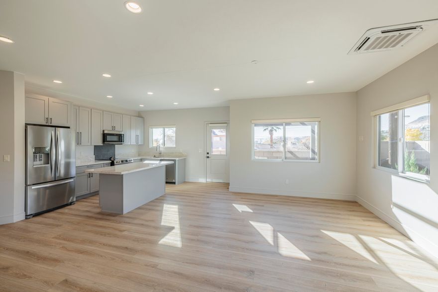 This beautiful, brand new home is situated on a 1/5th acre lot  in the heart of the vibrant city of St. George with easy access to all services, including dining, entertainment, retail and healthcare.  The home has 2,634 square feet with 3 bedrooms and 3 bathrooms, including an ADU unit that is ideal for a mother-in-law suite; a rental property; or a private space for adult children.  2 fully equipped kitchens (refrigerators, dishwashers, ranges, sinks) and 2 laundry rooms make this the ideal home for extended families or to collect rental income to help defray a monthly mortgage payment.  Luxury vinyl plank flooring throughout, granite countertops, lots of natural light, generous closets and storage spaces,  2 car garage and small fenced in yard perfect for family. Come see 313 for yourself.  Enjoy city living at its finest.